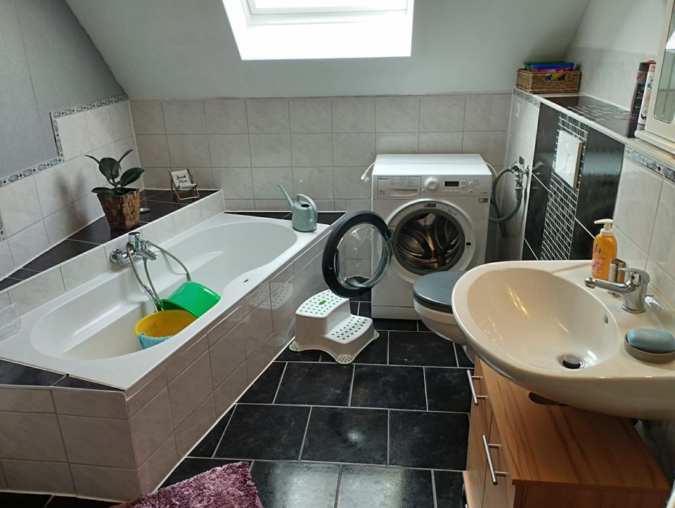 Badezimmer mit Badewanne und Waschmaschine